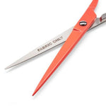 Red fabric shears with silver metal blades, featuring the text 'FABRIC ONLY' printed on one blade, set against a plain white background.