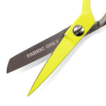 Bright yellow fabric shears with silver metal blades, one blade printed with the words 'FABRIC ONLY', shown on a clean white background.