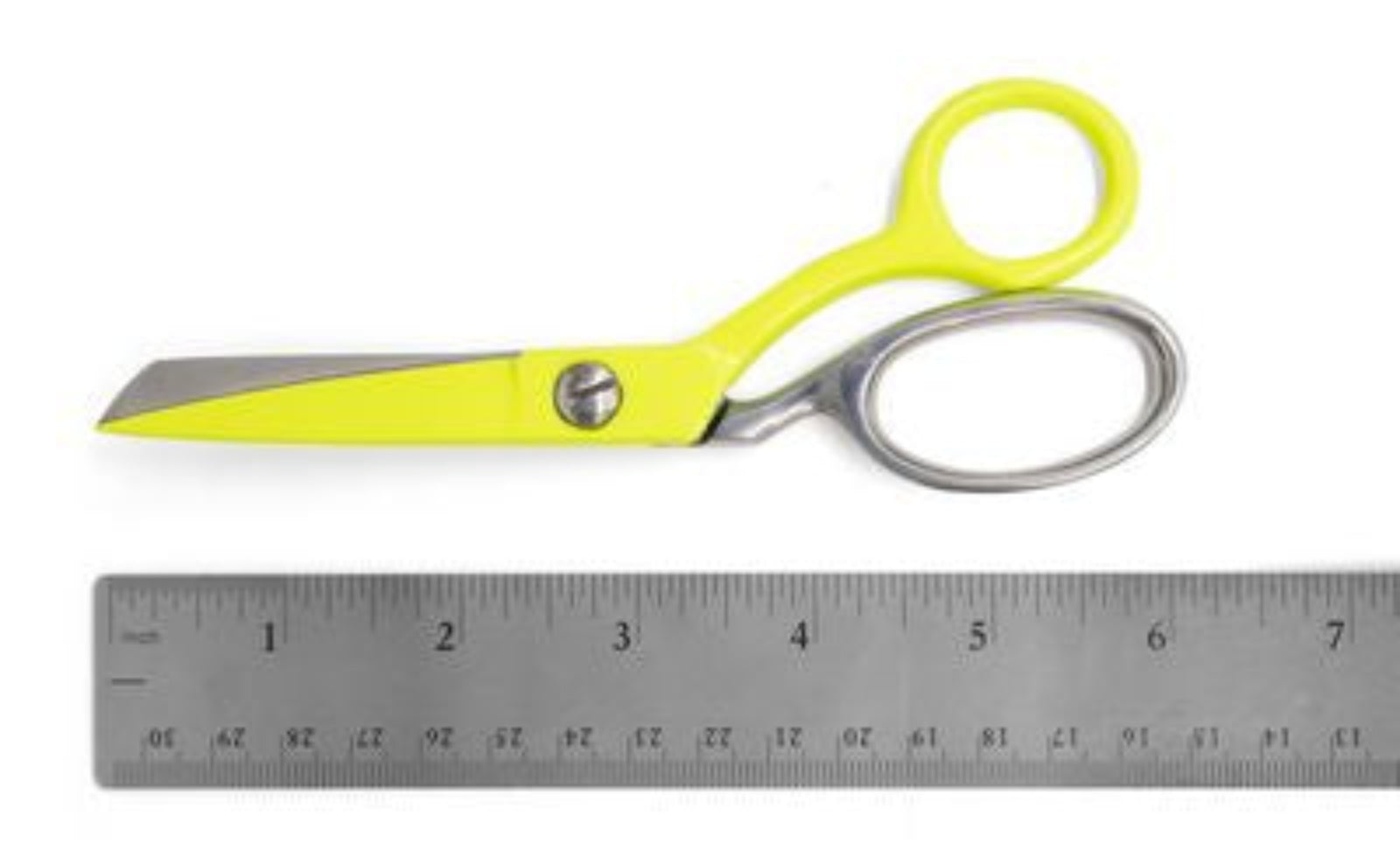 Bright yellow-handled scissors with silver metal blades and a metal loop, shown above a gray ruler on a white background.