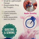 ToolTron Attachable Thumb/Finger Magnifier in its retail packaging, featuring a blue magnifying ring and a blue adjustable clamp on a pink and white background.