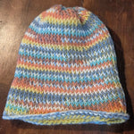 Tunisian crochet hat with the brim unfolded, showing colorful pastel stripes and clear stitch texture.