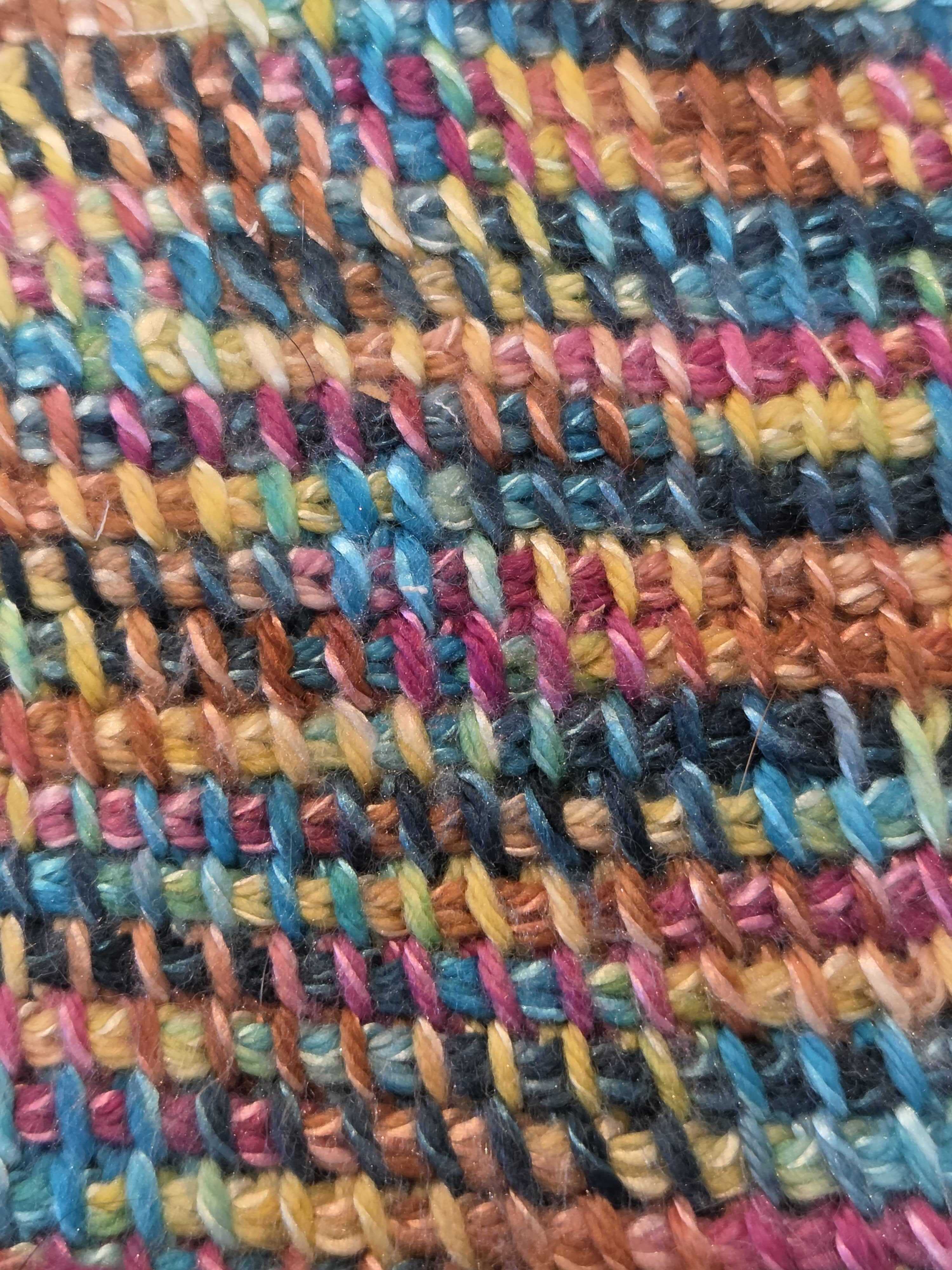 Detailed close‑up of a Tunisian crochet sample worked in variegated yarn, highlighting the stitch texture and color variation.