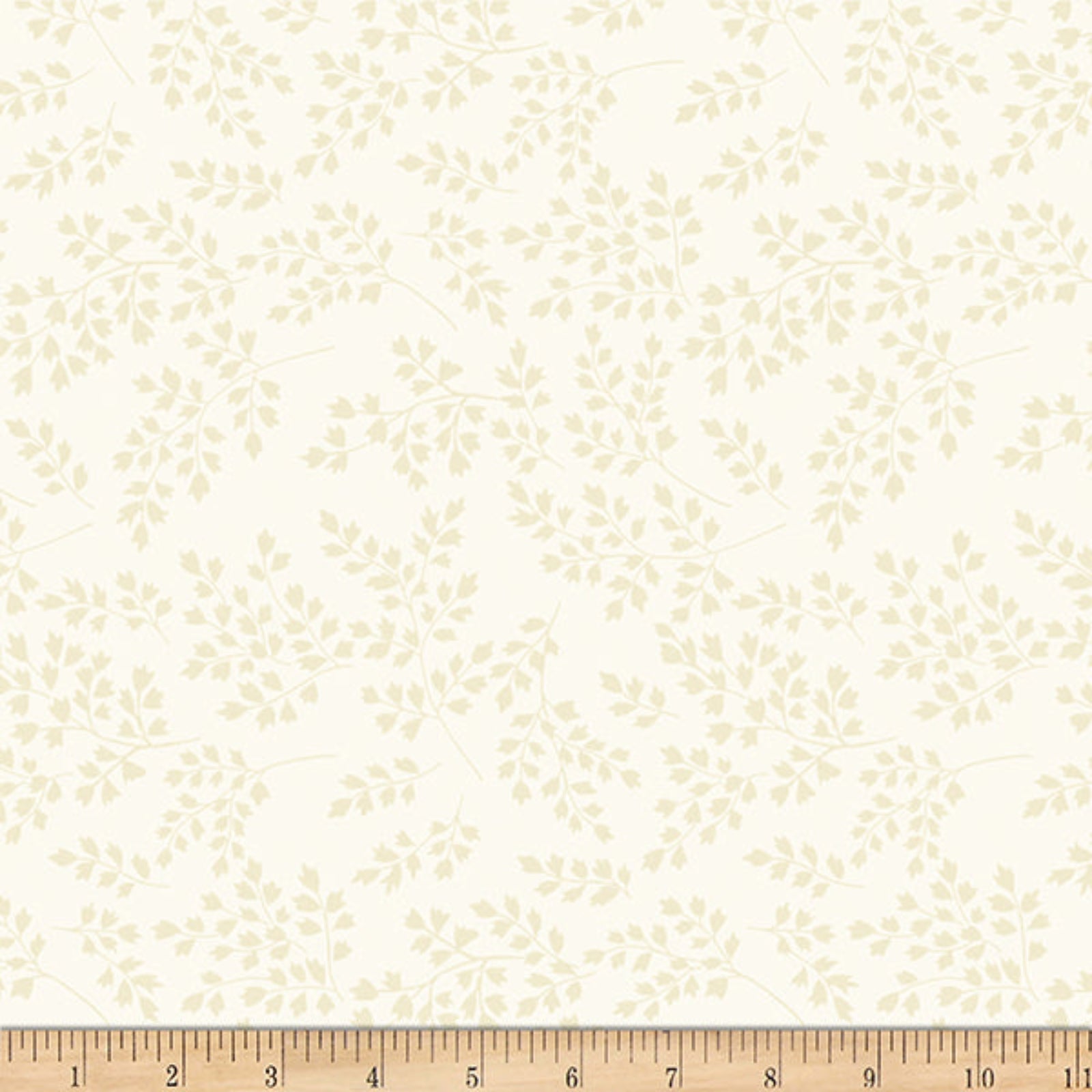 A repeating floral branch pattern in pale beige on an off-white background, with a wooden ruler along the bottom edge for scale.