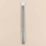 A packaged pair of black and white striped zippers sealed in a clear plastic sleeve with a white header card, set against a solid beige background.