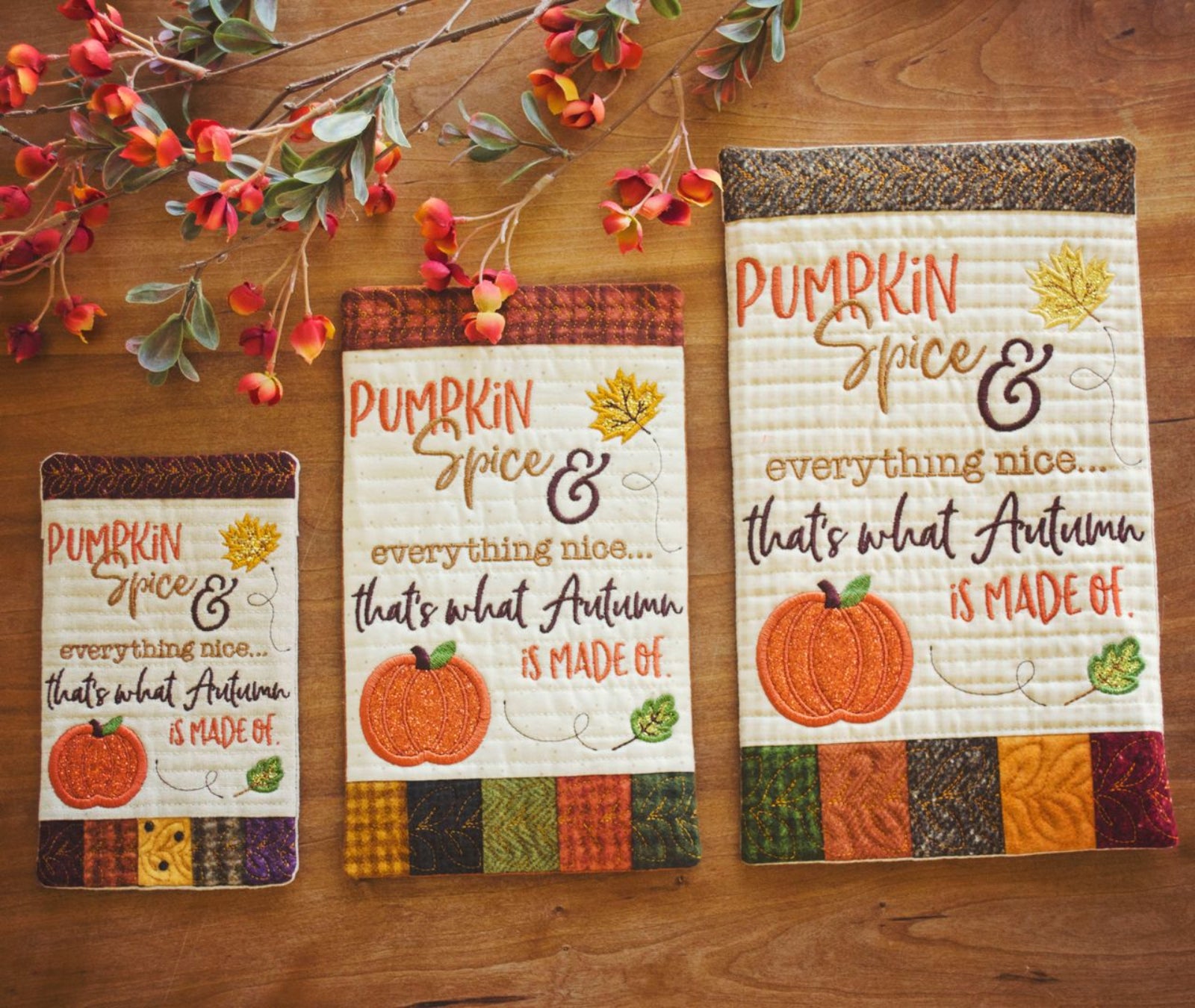 Three autumn-themed quilted fabric signs with embroidered text reading 'Pumpkin Spice & everything nice.
