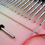 Set of metal needles with pink cable on a gradient background