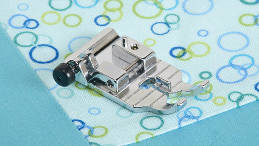 Metal sewing machine foot on a fabric with colorful circle pattern