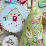 Embroidery hoops with colorful stitched designs on a wooden surface