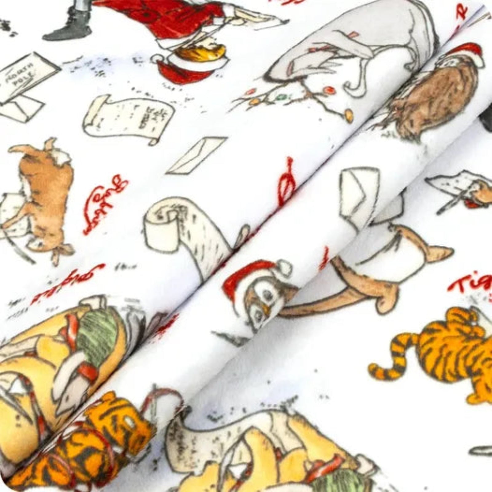A close-up of folded white fabric printed with a whimsical cartoon animal pattern featuring Santa Claus, a tiger, a owl, and red handwritten-style text.
