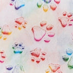 A close-up of a fabric or wallpaper pattern featuring colorful pastel paw prints in pink, blue, green, and yellow on a light, watercolor-textured background.