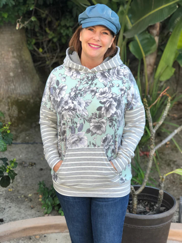 Outdoor view of the Del Mar Hoodie worn with a creative mix of prints for a fresh, updated look, showing the hooded style and front pocket
