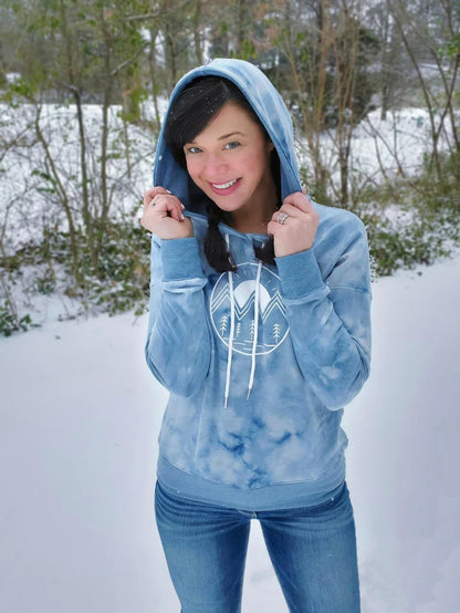 Outdoor winter view of the Del Mar Hoodie worn in the snow, showing the front design and hooded style