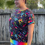Outdoor view of the Del Mar Top worn in a yard setting, showing the garment’s fit and neckline without a hood