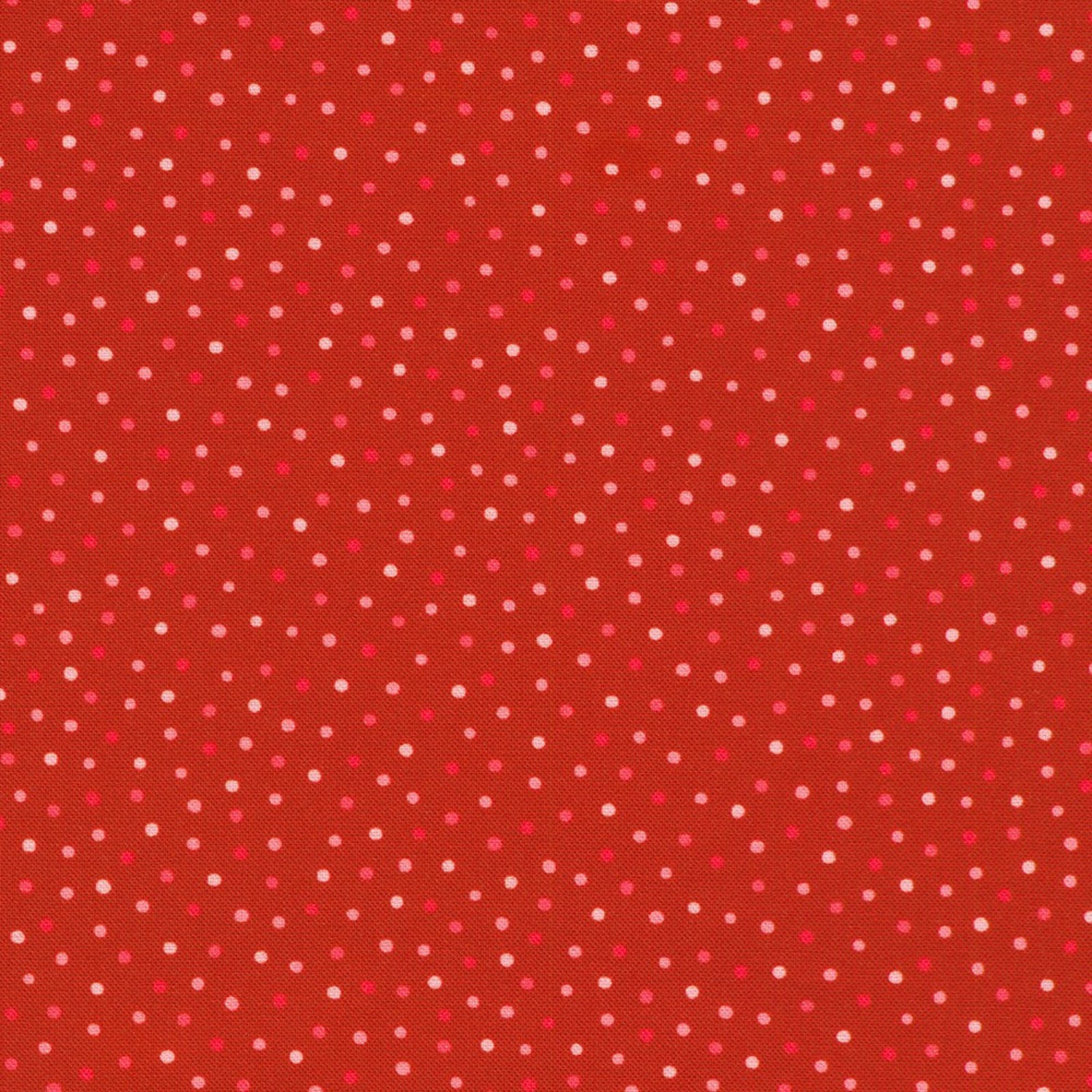 A close-up of a red fabric or material swatch with a repeating pattern of small white and pink polka dots.