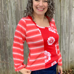 Outdoor view of the long‑sleeve Florence Top featuring a floral front panel with coordinating striped sleeves, shown against a wooden fence backdrop