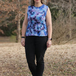 Outdoor view of the sleeveless Florence Top worn in a relaxed setting, showing the clean neckline and tie‑dye knit fabric against a natural backdrop