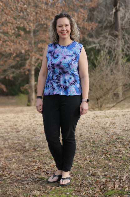 Outdoor view of the sleeveless Florence Top worn in a relaxed setting, showing the clean neckline and tie‑dye knit fabric against a natural backdrop