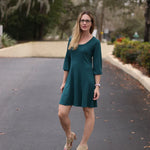 Outdoor view of the Florence Tunic worn in a knee‑length option with three‑quarter sleeves, shown in a natural garden setting
