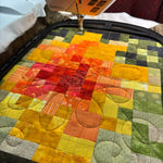 Close‑up of a BERNINA B 990 quilting a colorful patchwork design in the Giant Hoop