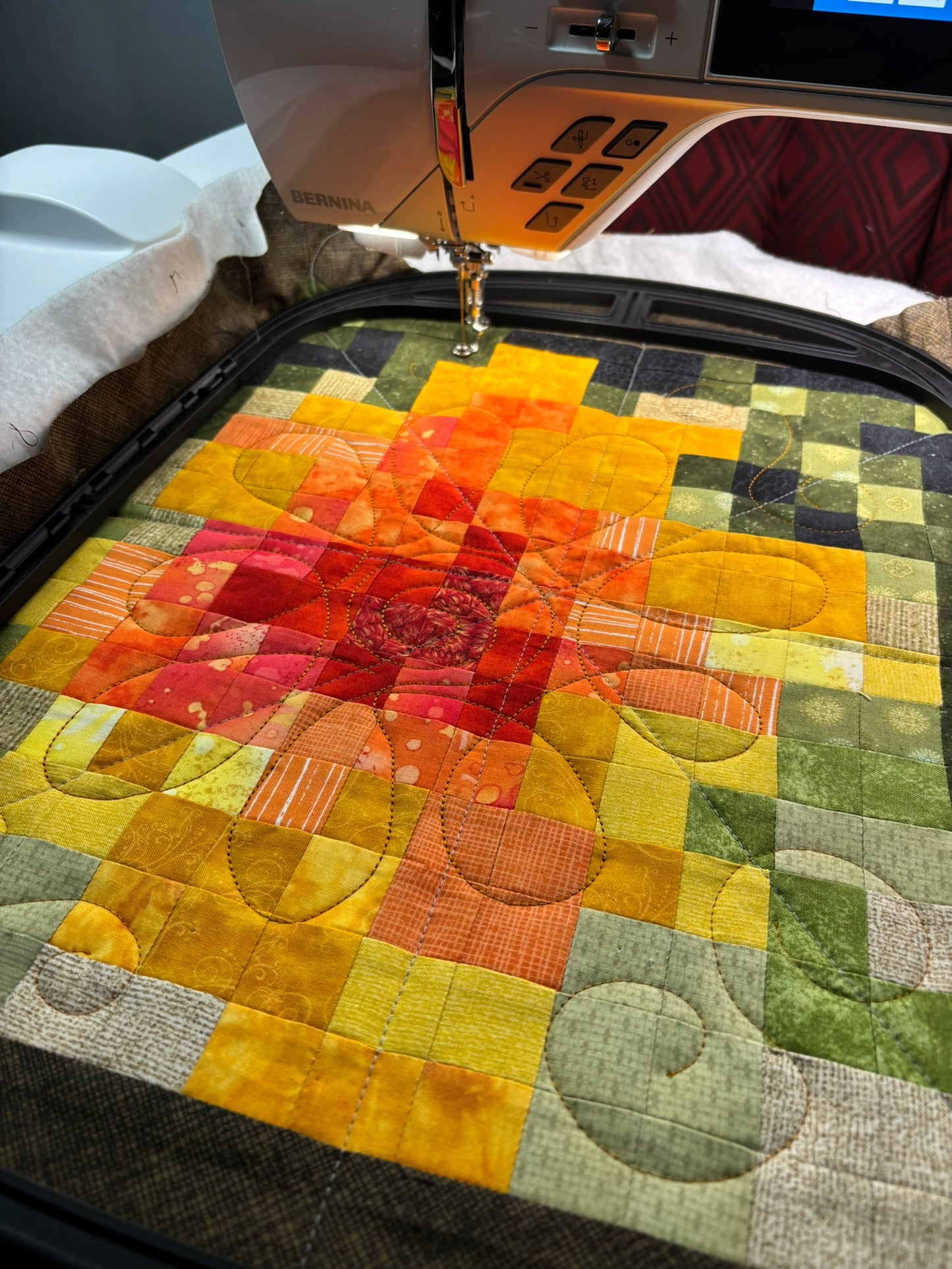 Close‑up of a BERNINA B 990 quilting a colorful patchwork design in the Giant Hoop