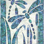 Nature‑themed appliqué design with two dragonflies and cattails cut from blue and green fabric against a textured background