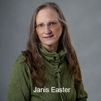 Headshot of instructor Janis Easter wearing glasses and a green textured sweater, smiling in front of a gray background.