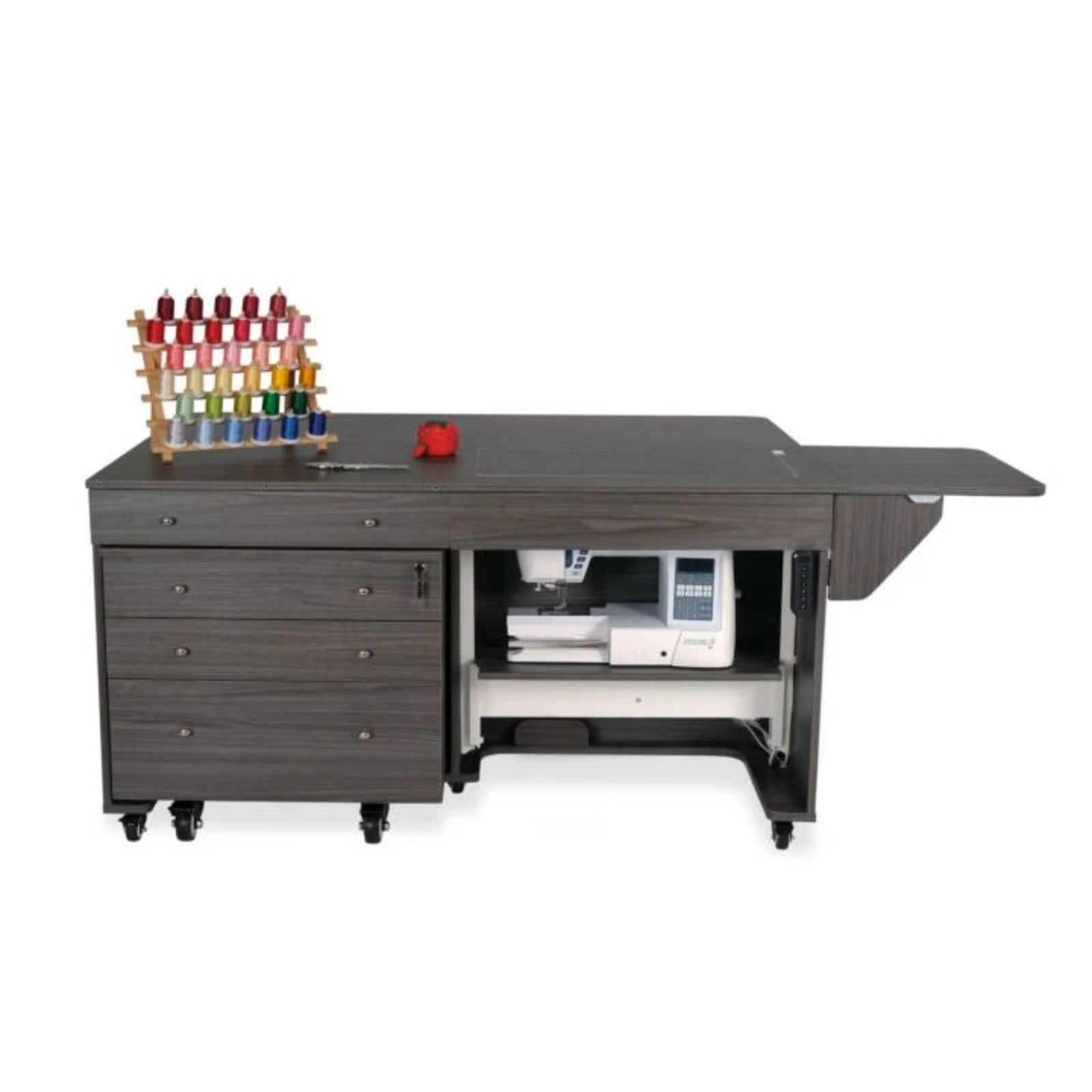 Sewing machine on a large dark wooden worktable with drawers and spools of thread.