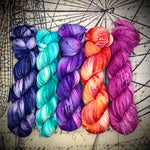 Five hand‑dyed yarn skeins in a fade set featuring blue, turquoise, purple, orange, and magenta tones.