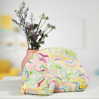 Marbled pastel zippered bag displayed with a floral vase in a soft, modern room setting