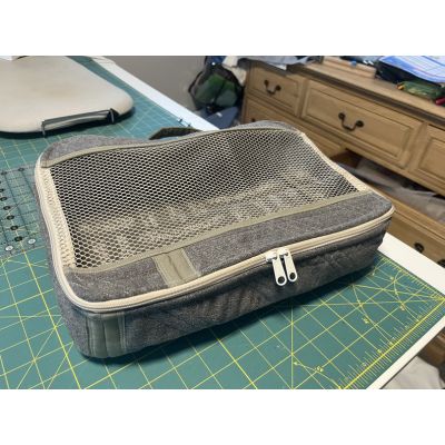 Finished Pack It In 2.0 bag sewn by Sonia, shown on a cutting mat with the mesh top and double zipper visible.