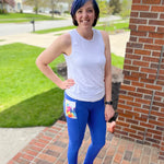 Outdoor view of the Pittsburgh Walking Pants sewn as leggings with a patterned pocket panel, worn with a sleeveless athletic top on a brick porch