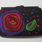 Black clutch with a colorful felted spiral design created using the PunchWork tool.