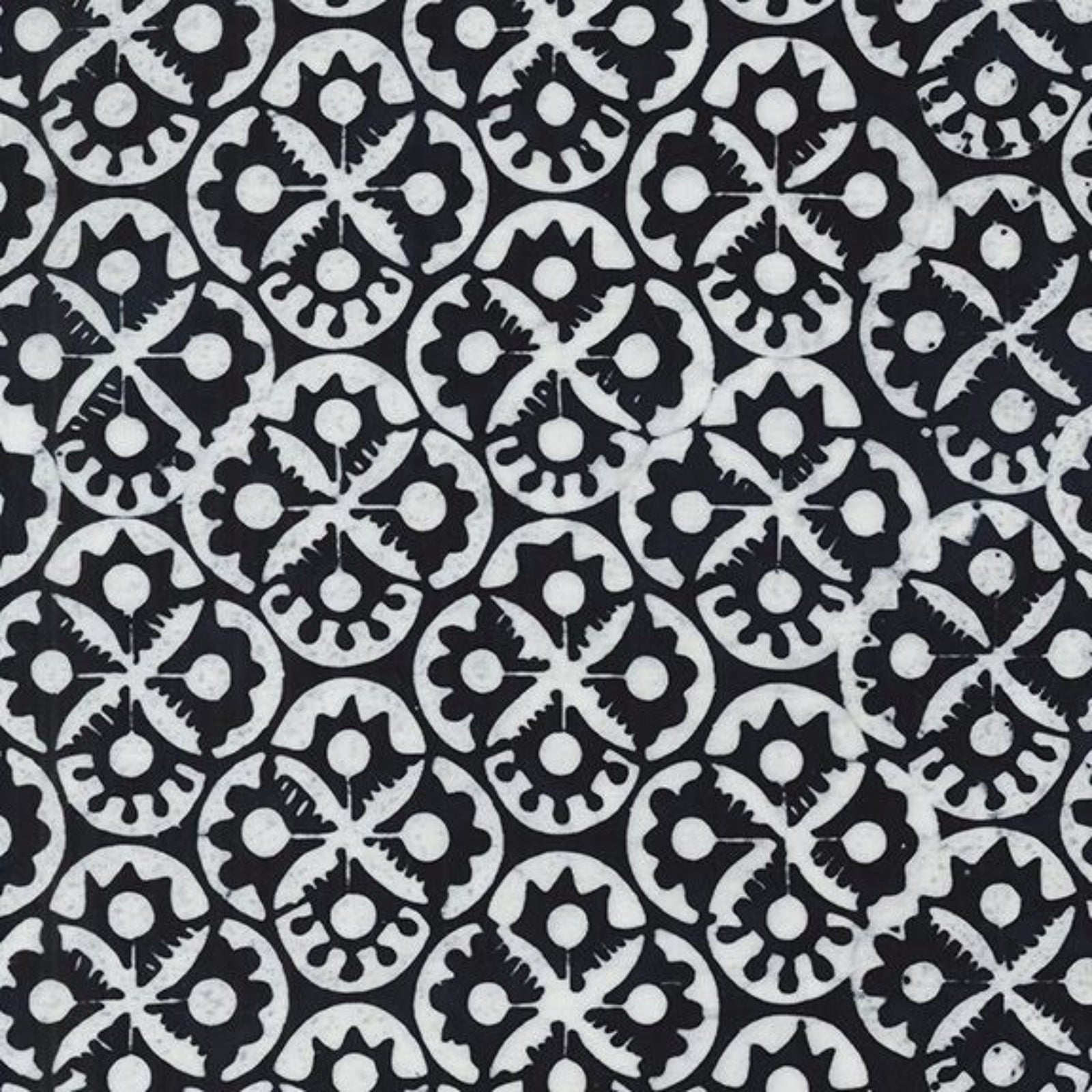 Black and white patterned fabric featuring a repeating hand-drawn style floral and geometric medallion design.