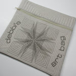 Quilted zippered pouch with geometric stitching and embroidered ‘debbi’s art bag’ lettering