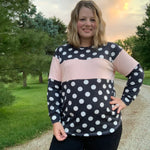 Outdoor view of the Santa Fe Top sewn without a hood, featuring long sleeves and a polka‑dot and color‑block design, worn at sunset on a gravel path