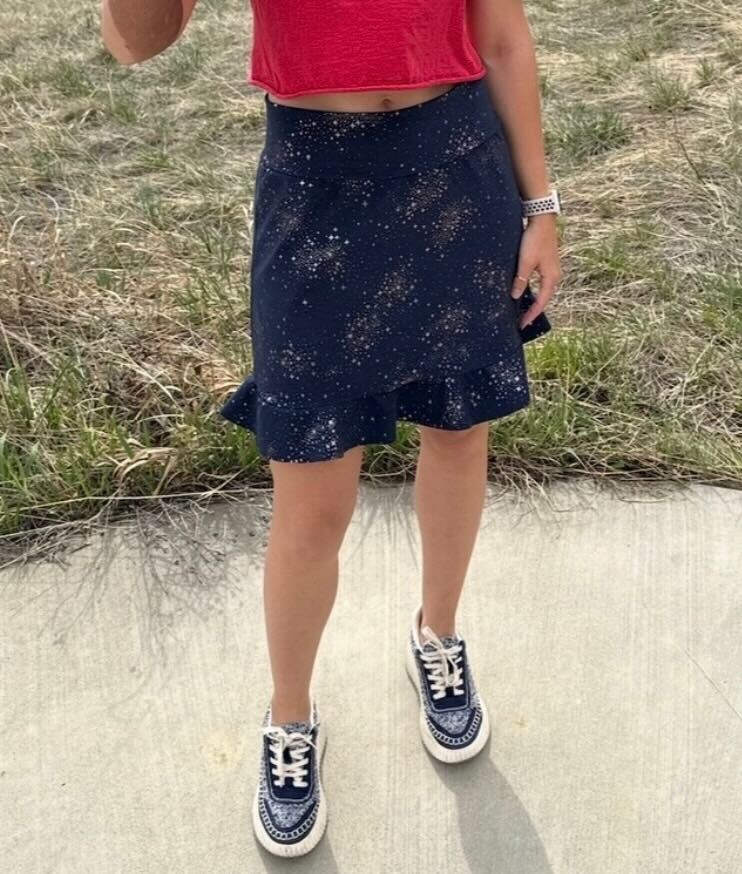 Person wearing a handmade skort from the Sulky Tee & Skort Workshop, shown in a front view with a ruffled hem and star‑patterned fabric.