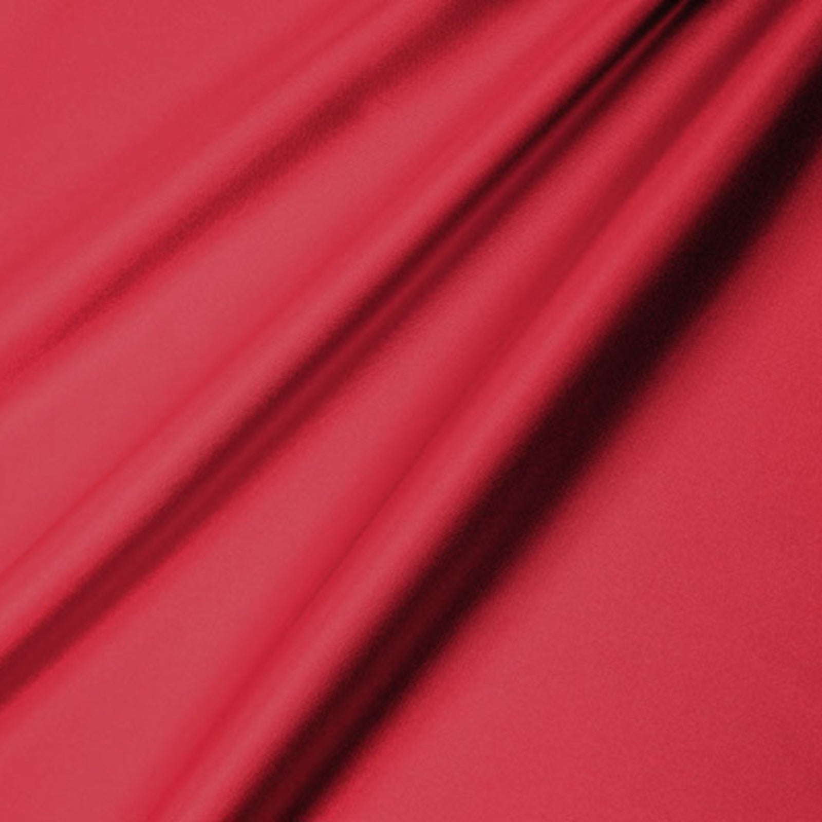A close-up of draped red fabric with soft folds and a smooth texture.