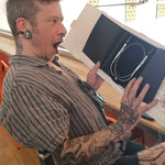 A Stitch ’n Bitch prize winner holding up a pair of Skacel circular needles inside Barley Pop Brewing.