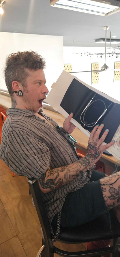 A Stitch ’n Bitch prize winner holding up a pair of Skacel circular needles inside Barley Pop Brewing.