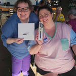Two Stitch ’n Bitch prize winners at Barley Pop Brewing holding Skacel knitting and crochet tools and smiling during the event.