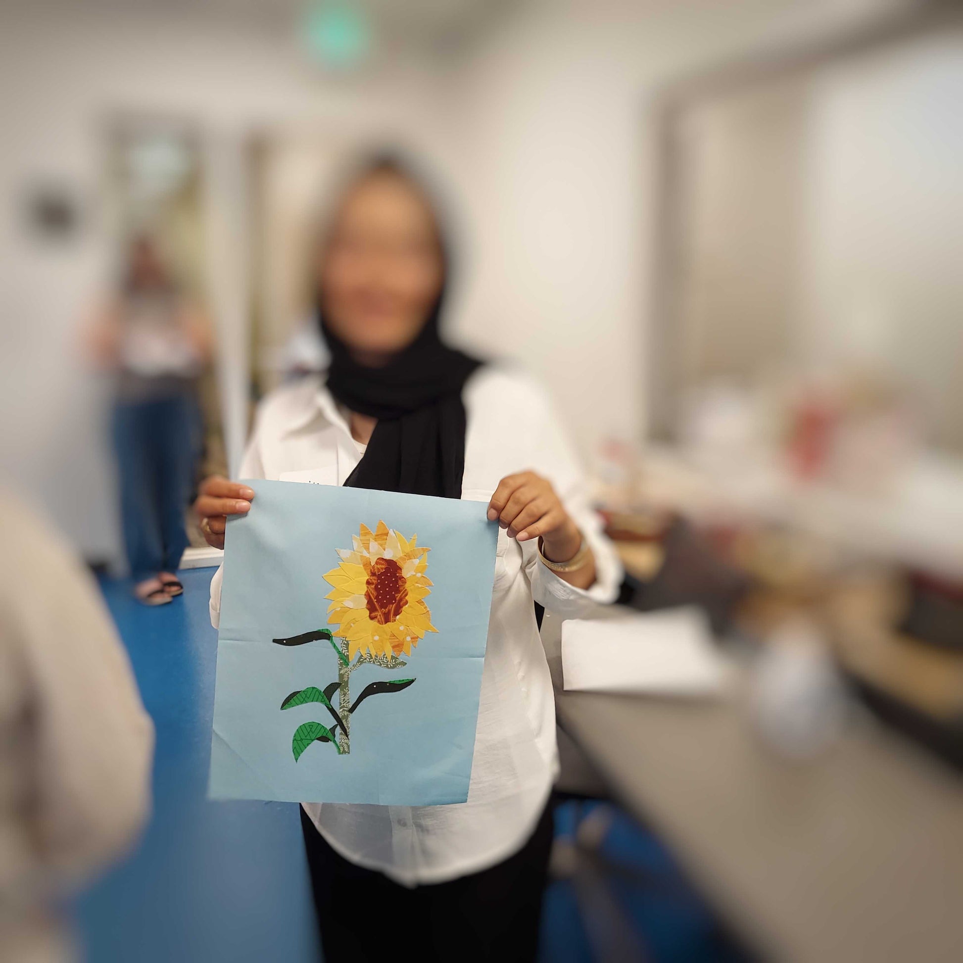 Student displaying their finished sunflower collage block created using the parchment pressing technique.