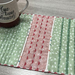 A colorful mug mat stitched on the Baby Lock Triumph, featuring decorative serger stitches on pieced fabric strips.