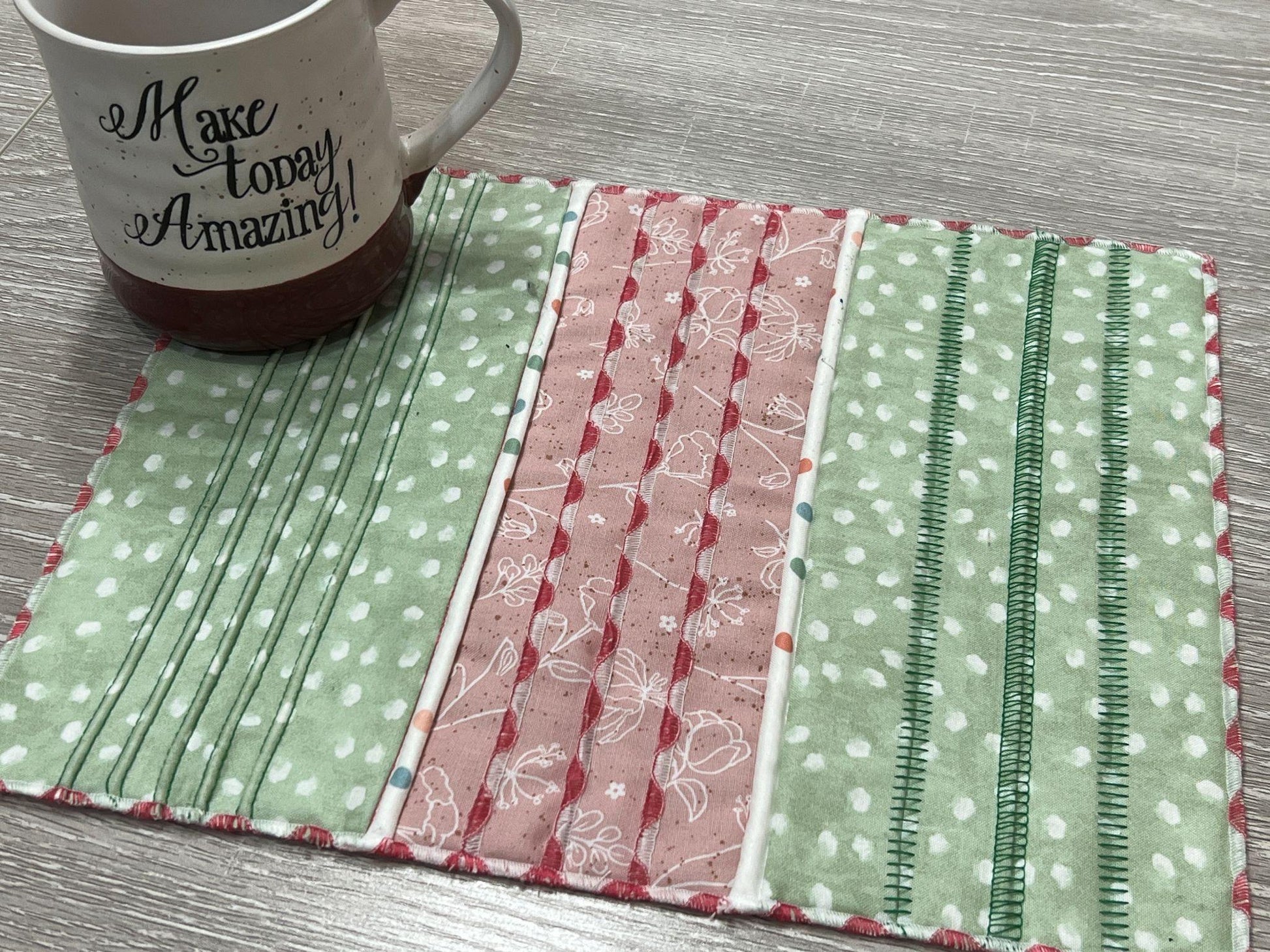 A colorful mug mat stitched on the Baby Lock Triumph, featuring decorative serger stitches on pieced fabric strips.