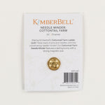 KimberBell Needle Minder: Cottontail Farm enamel pin on its original backing card. The card is white with gold and orange text, featuring a gold-colored circular pin with a bunny cutout in the center.
